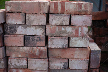 Fototapeta premium Old brick wall with cracks and scratches. Horizontal wide brickwall background. Distressed wall with broken bricks texture. Vintage house facade.