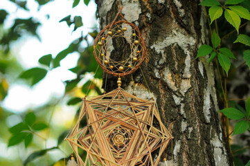 Golden star dreamcatcher mandala with feathers in park