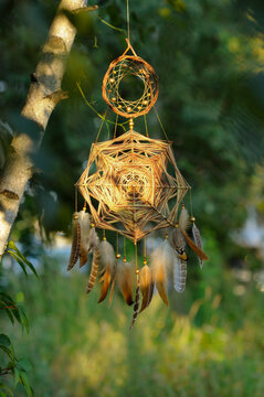 Golden star dreamcatcher mandala with feathers in park