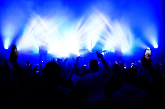 Blurred View Of The Stage In The Light Of Spotlights From The Crowd At A Concert. Funny Dances At A Music Festival. Show Poster