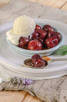 A nice bowl of cherries jubilee with scoop of vanilla ice cream
Sumptuous dessert
