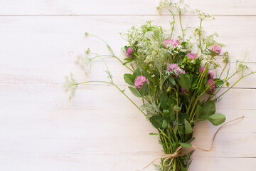 Bouquet of wild flowers pn white wooden background