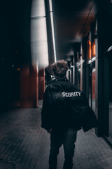 male with a security jacket walk in night street
