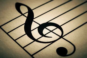 Black treble key sign macro close-up printed on a musical chart