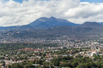 Fototapeta na wymiar Aerial view of the most southern part of Mexico City, above Tlalpan district and with the mountains Ajusco and Xitle in the back