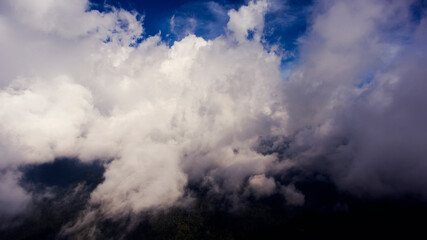 Obraz premium View from the cockpit of an amazingly beautiful white, fluffy clouds over green Asian island and sea water. Wonderful sky over Indian ocean