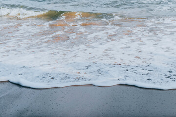 Calm sea waves wash over beautiful sand of the jungle beach
