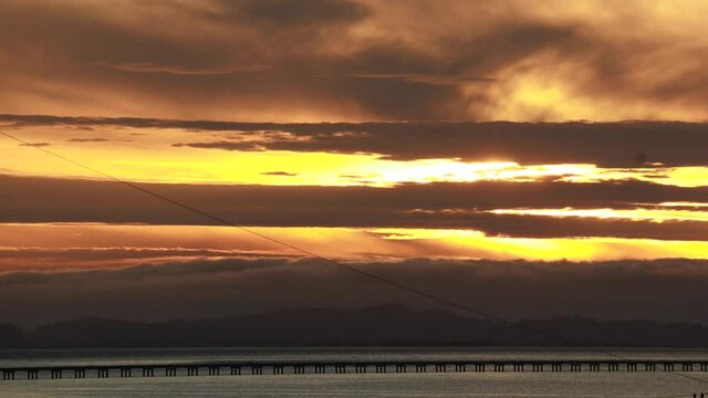 Sunset along the straight low section of Astoria Megler bridge Oregon to Washington slow moving clouds