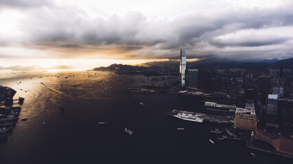 Fototapeta na wymiar Aerial photo from flying drone of a developed Hong Kong city view with many buildings with contemporary design and sea with riding luxury yachts and truck ships. Cityscape with modern skyscrapers