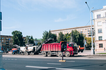 Naklejka premium Minsk, Belarus, 5.05.2020: repair work in the city, road repair, tractor and worker, city roads, road signs