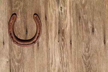 Horseshoe middle left of frame on a wood grain patterned door symbol of good luck 