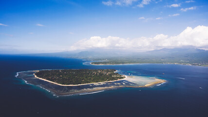 View from airplane cockpit of small undeveloped coast with beautiful coral bottom, perfect place for snorkeling and diving lessons. The Gili Island without cars and motorbikes, ecological clean place