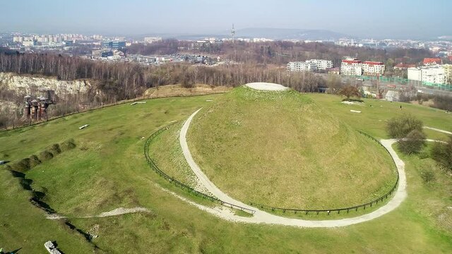 Krakus Mound in Krakow, Poland. The origin of the mound, probably early medieval kurgan, is not known. Old quarry in front. City panorama in the background. Aerial 4K video.