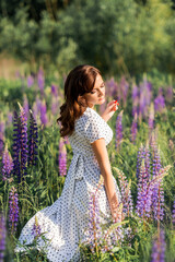 Girl in a flower field with lupins. Summer photo in nature