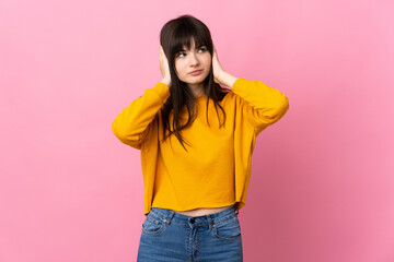 Young Ukrainian woman isolated on pink background frustrated and covering ears