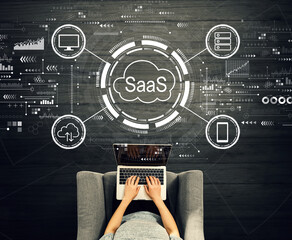 SaaS - software as a service concept with person using a laptop in a chair