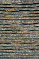 fence of unedged boards, which are stylishly painted in brown and gold tones. texture of the old wood