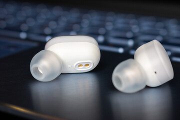 wireless bluetooth headphones on laptop background close-up