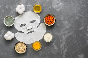 Obraz na płótnie Canvas Face mask and natural homemade cosmetic ingredients on a gray concrete background. The concept of beauty and rejuvenation. Top view, flat lay.