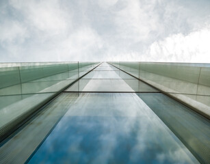 Modern glass office building agaist the cloudy sky.