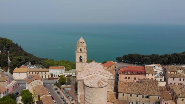 4K aerial drone video clip - View from drone flying over an old church in  Sirolo old town, Italy.