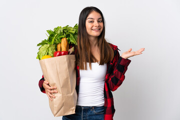 Young caucasian with vegetables isolated on white background with shocked facial expression