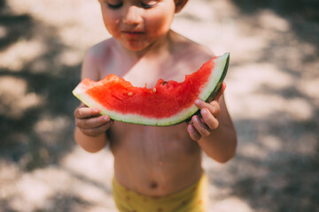 A boy child in Panama eats watermelon in the summer in the forest Emotionally and fun