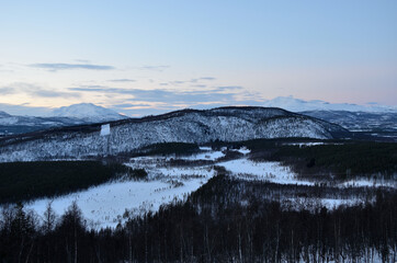Deep scenic snow covered mountain range and forest in the arctic circle in January 2014