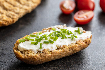 Crispbread with creamy cheese., green chive and tomatoes