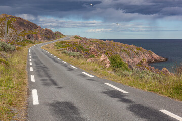 The twisting road along the stony coast of the Barents Sea, Finnmark, Norway