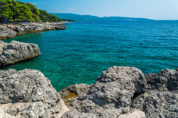 Amazing beach with stones and cliffs in Krk town. Krk town is a famous touristic destination on Krk island, Croatia. Space in right side