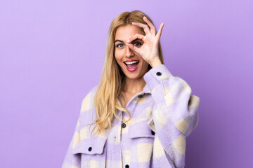 Young Uruguayan blonde woman over isolated background showing ok sign with fingers