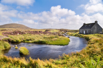 A cottage perched on the Isle of North Uist in the Outer Hebrides in Scotland - obrazy, fototapety, plakaty