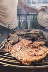 setting charcoal to make a family barbecue of meat on a grill