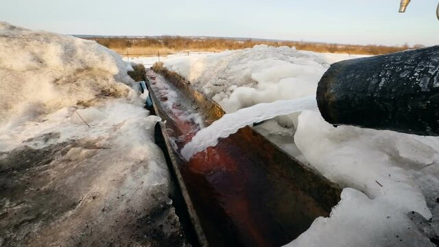 Drain outfall in winter. Drinage system outside. Water pipe in process.
