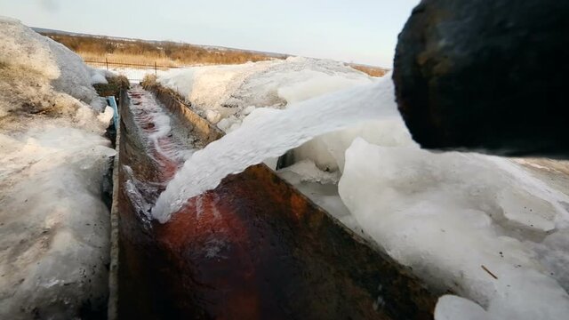 Drain outfall in winter. Drinage system outside. Water pipe in process.