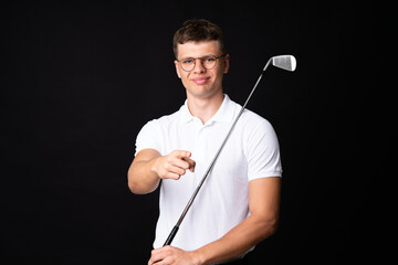 Handsome young golfer player man over isolated black background