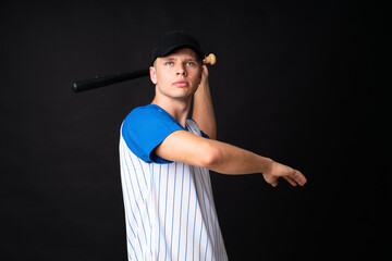 Young man playing baseball over isolated black background