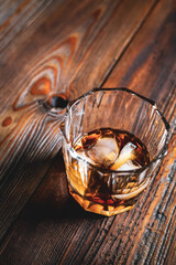 single malt whiskey with ice on the rock on wooden table top view