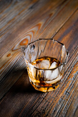 single malt whiskey with ice on the rock on wooden table top view