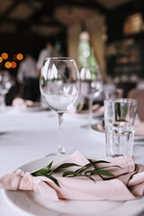 Table setting at restaurant.Wedding setting table.Tableware and decorations for serving a festive table. Plates, wine glasses and cutlery with decorative textile 