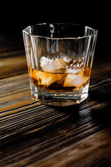 single malt whiskey with ice on the rock on wooden table top view