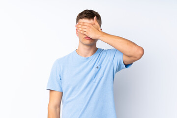 Young handsome man over isolated white background covering eyes by hands. Do not want to see something