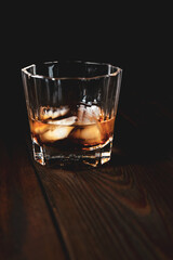 whiskey and ice on a wooden table dark background