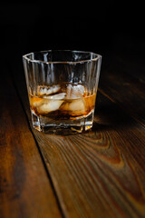 whiskey and ice on a wooden table dark background