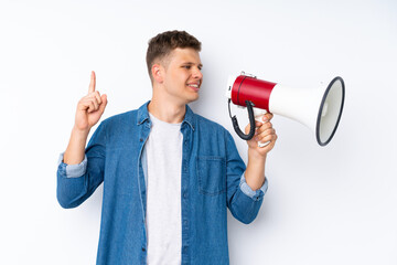 Young handsome man over isolated white background shouting through a megaphone