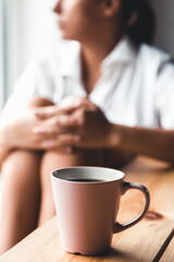 Woman in a white t-shirt holds morning coffee in a pink ceramic cup. Manicure. Front view