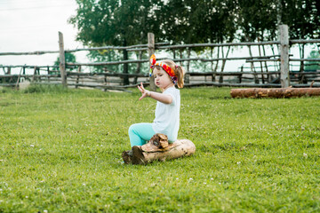 sweet pretty child, girl sitting on a fence in the village. walks in the countryside. farming.