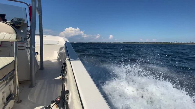 POV side of a white boat across a bay in the Gulf of Mexico