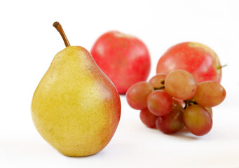 pear fruits, yellow fruits with red edges on the background of apples and grapes, grapes